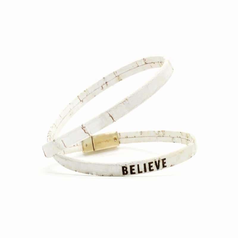 Believe bracelet made of thin white cork with a gold magnetic clasp.